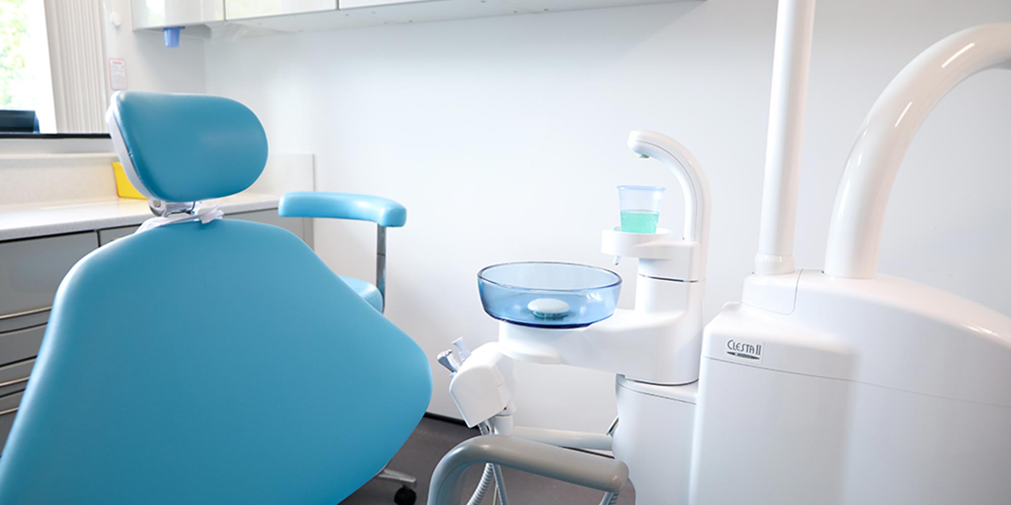 blue dental chair and rinsing sink in treatment room