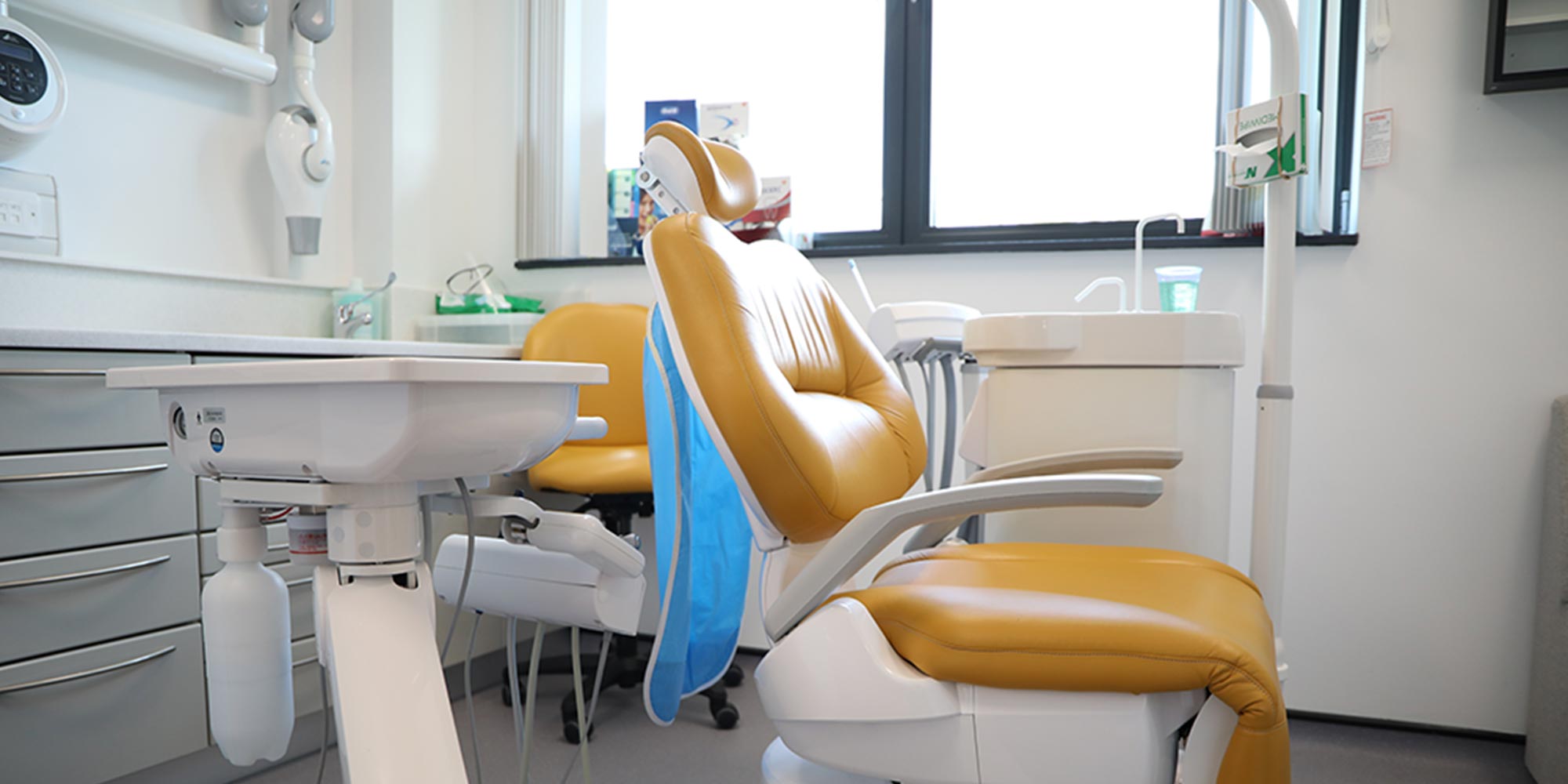 side-view of orange dental chair in clean, white treatment room