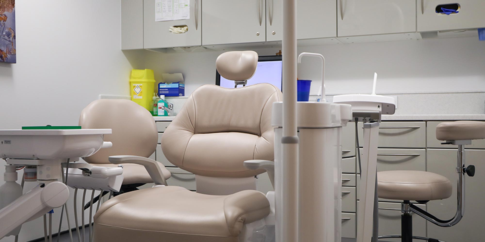 beige dental chair in clean, white treatment room