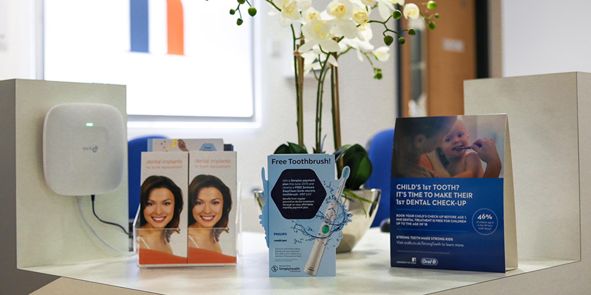 dental check by one, free toothbrush and dental implants brochures on reception desk